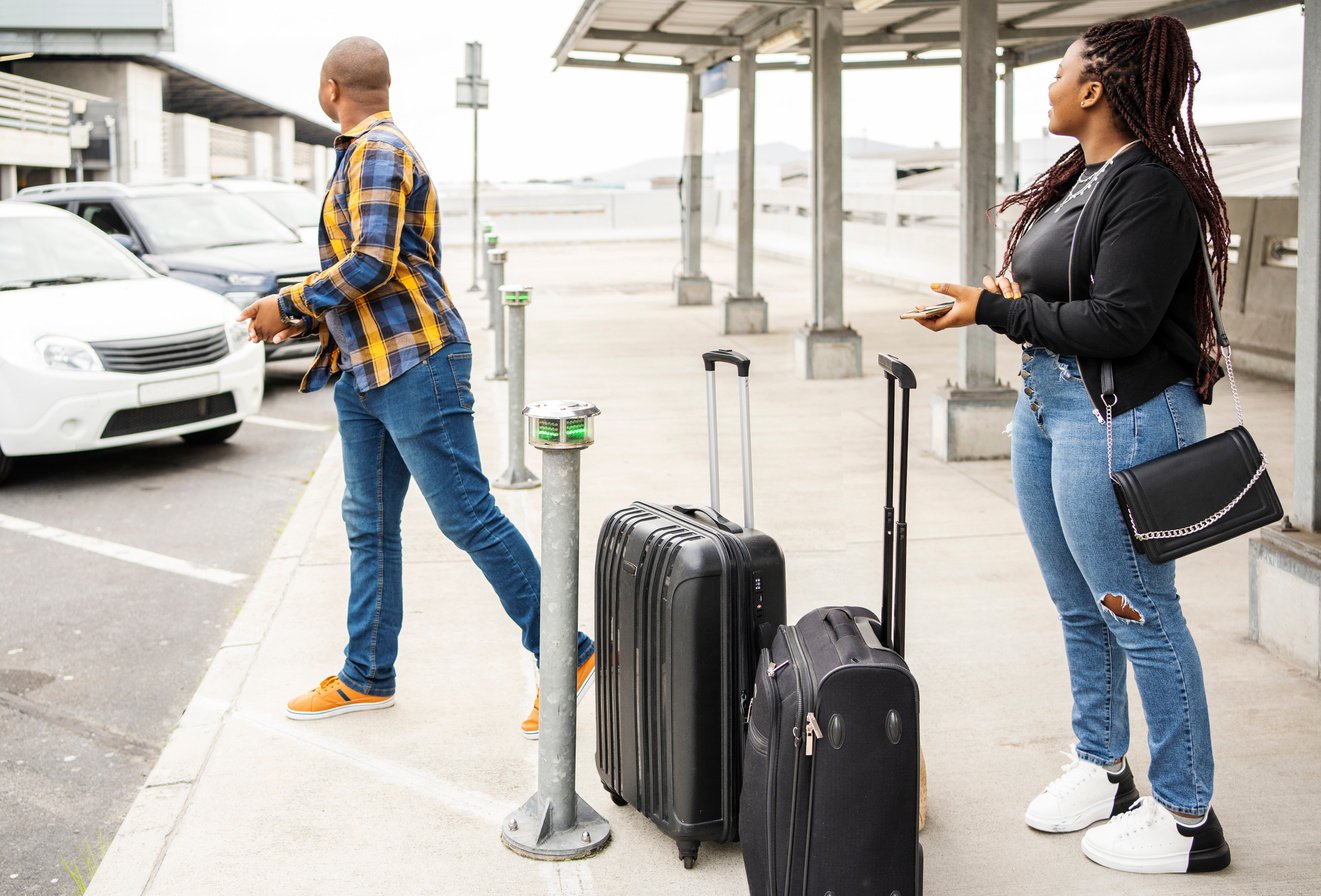 Young couple looking for their taxi at an airport pickup area